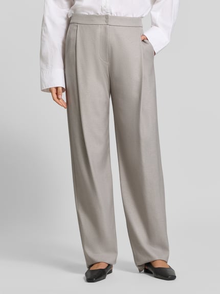 Frauenmodel trägt Straight Fit Hose mit Viskose-Anteil von Emporio Armani in hellem Beige mit Bundfalten, Glattstrukturoptik, Nahaufnahme Unterkörper, Damen Hose, Armani.