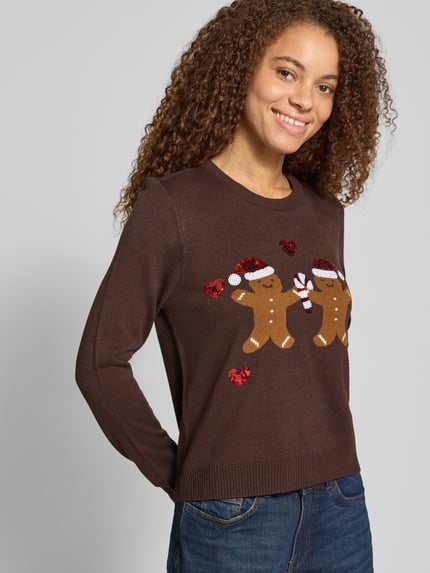 Frauenmodel trägt Rollkragenpullover mit weihnachtlichem Motiv-Print von ONLY, mehrfarbig, Strickoptik, Ganzkörperansicht von vorne.