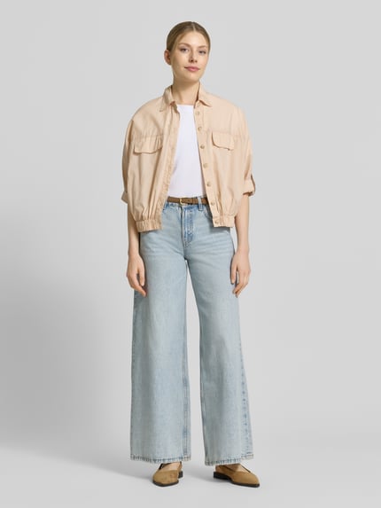 Frauenmodel trägt Blouson aus Baumwolle mit Knopfleiste von Emily Van den Bergh, Reine Baumwolle, Regular-Fit, Umlegekragen, Ärmel mit Aufschlag, beige, strukturierte Optik, Ganzkörperansicht von vorne.