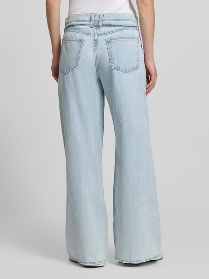 Frauenmodel trägt Baggy Jeans mit Bindegürtel von GAP in hellblauem Baumwoll-Lyocell-Mix, lockerer Baggy Fit, Ganzkörperansicht Rückansicht.