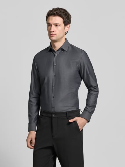 Männermodel trägt Slim Fit Businesshemd aus reiner Baumwolle von Jake*s, unifarben, Kentkragen, Ganzkörperansicht von vorne.