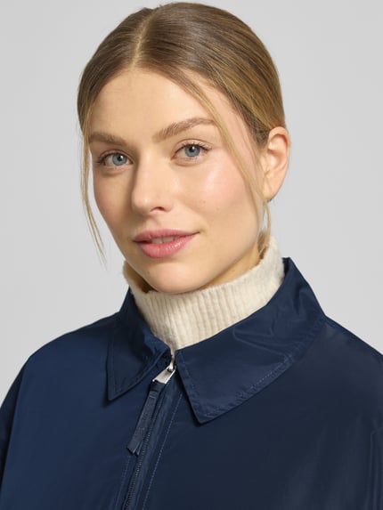 Vrouwenmodel draagt Jacke mit Pattentaschen Modell 'CICAMI' van CINQUE in donkerblauw met platte kraag, ritssluiting, regular fit, klepzakken; ruglengte maat 36: 58 cm, schouderbreedte: 50 cm, borstwijdte: 56 cm, mouwlengte: 59 cm, Nahaufnahme bovenlichaam.