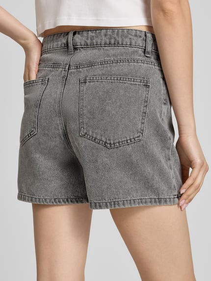 Frauenmodel trägt Regular Fit Jeansshorts aus Baumwoll-Mix Modell 'ABBI' von Pieces in grauer Denim-Optik mit 5-Pocket-Design, Ganzkörperansicht Rückansicht.