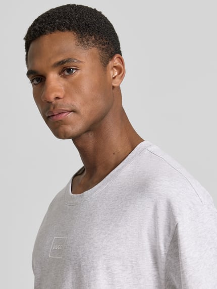 Männermodel trägt Regular Fit T-Shirt aus Baumwoll-Mix Modell 'LAZE T-SHIRT' von HUGO, Optik: Unifarben, Label-Print, Rundhals, Kurzarm, Nahaufnahme Oberkörper.
