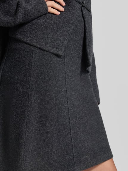 Frauenmodel trägt Knielanger Rock aus reiner Wolle von Christian Berg Woman, A-Linie, knielang, dunkelgrau, Nahaufnahme Oberkörper.
