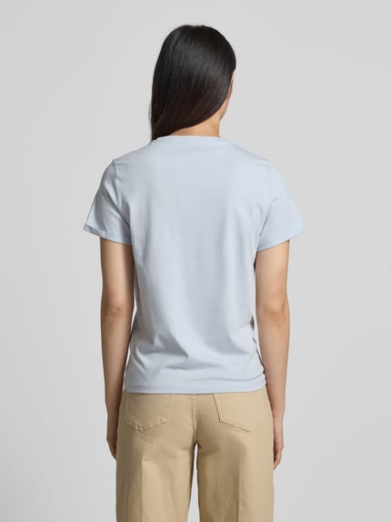 Modelka nosi Regular Fit T-Shirt aus reiner Baumwolle od Tom Tailor, efekt: jednolity kolor, krój regular fit, nadruk z motywem i logo, okrągły dekolt, krótki rękaw z zakończeniem rękawów, wykończenie materiału: dżersej, 100% bawełna, widok całej sylwetki z tyłu.