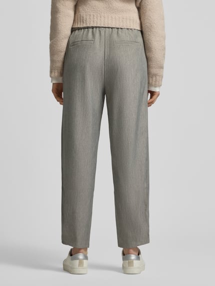 Modelka nosi Straight Fit Stoffhose mit Gesäßtaschen Modell 'Caia' von FREE/QUENT, szary odcień, krótka długość, widok całej sylwetki od tyłu. Szerokość w rozmiarze S: 40 cm, długość wewnętrzna nogawki: 71 cm, elastyczna bawełna.