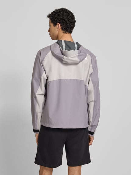 Männermodel trägt Regenjacke mit Logo von The North Face in Grau und Violett, Regular Fit, Kapuze, Reißverschluss, Rückenansicht, Rückenlänge bei Größe M 70 cm, Schulterbreite 50 cm, Brustweite 62 cm, Ärmellänge 76 cm.