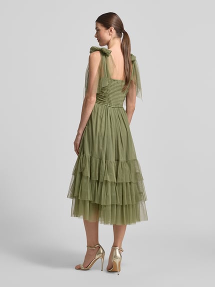 Frauenmodel trägt Cocktailkleid aus Tüll im Stufen-Look von LACE & BEADS in Olive, A-Linie, Midikleid, Drapierungen, Ganzkörperansicht Rückansicht.