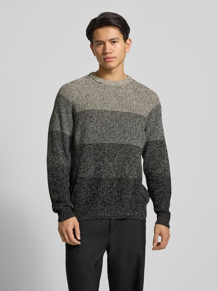 Męski model nosi Relaxed Fit Strickpullover aus reiner Baumwolle Modell 'BIRK' od Only & Sons, melanżowa ombré, długi rękaw, widok całej sylwetki z przodu.