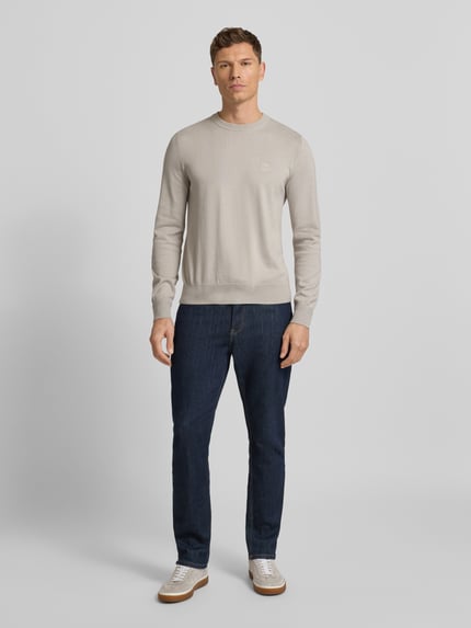 Männermodel trägt Regular Fit Pullover aus Baumwoll-Kaschmir-Mix Modell 'KANOVANO' von BOSS Orange, Optik: Unifarben, Label-Patch, Rundhals, Strick, Ganzkörperansicht von vorne.