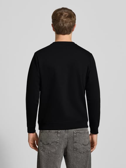Męski model nosi czarną bluzę 'Sweatshirt mit Motiv-Print' od CHILL PILL, mieszanka bawełny, krój regular fit, długość tyłu w rozmiarze M: 68 cm, długość rękawów w rozmiarze M: 66 cm, okrągły dekolt, widok całej sylwetki od tyłu.