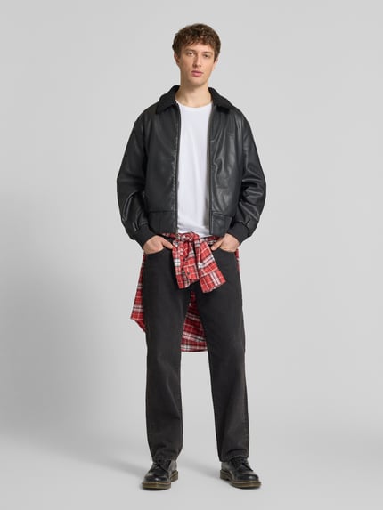 Männermodel trägt Herren T-Shirt mit Label-Patch von Alpha Industries in Weiß aus Reine Baumwolle, Gerader-Schnitt, Rundhalsausschnitt, Ganzkörperansicht von vorne. Rückenlänge bei Größe M: 66 cm.