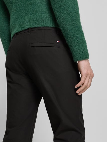 Männermodel trägt Straight Leg Hose aus atmungsaktivem Material Modell 'DENTON' von Tommy Hilfiger, Optik: Unifarben, Gesäßtaschen, Ganzkörperansicht Rückansicht.