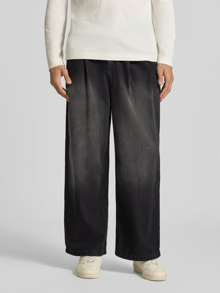 Männermodel trägt Regular Fit Jeans mit Bundfaltenoptik von Adidas Originals, Denim mit Farbverlauf und Used Look, 5-Pocket-Design, Ganzkörperansicht von vorne