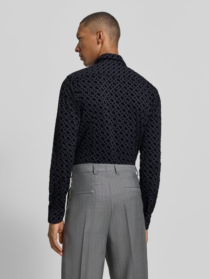 Mannenmodel draagt donkerblauw slim fit zakelijk overhemd met kentkraag van BOSS, grafisch patroon, grijze pantalon, achteraanzicht volledige lichaamsopname