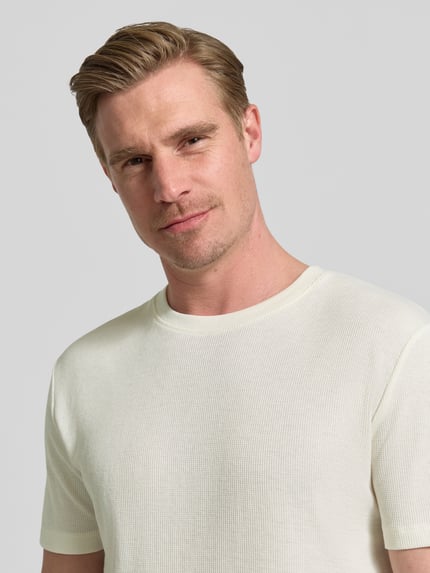 Männermodel trägt Regular Fit T-Shirt aus Baumwoll-Mix von Tom Tailor Denim in Optik: Unifarben, Piqué-Struktur, Nahaufnahme Oberkörper.