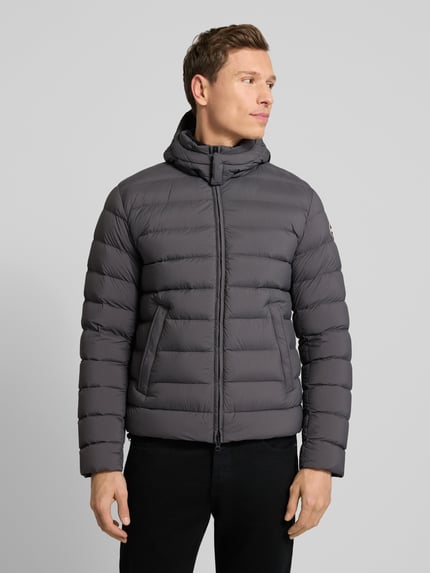 Männermodel trägt Kurtka pikowana mit kaptur von Colmar Originals, krój regular fit, zamek błyskawiczny, wpuszczane kieszenie, szara; Ganzkörperansicht von vorne. Długość tyłu 66 cm, szerokość ramion 42 cm, szerokość klatki piersiowej 56 cm, długość rękawów 66 cm, rozmiar 50.