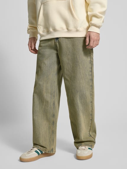 Męski model nosi Wide Fit Jeans mit Viskose-Anteil Modell 'Everyday' od ANOTHER COTTON LAB, bawełniany miks z dodatkiem wiskozy, szerokość w rozmiarze M: 37 cm, długość nogawki wewnętrznej w rozmiarze M: 29 cm, widok całej sylwetki z przodu.