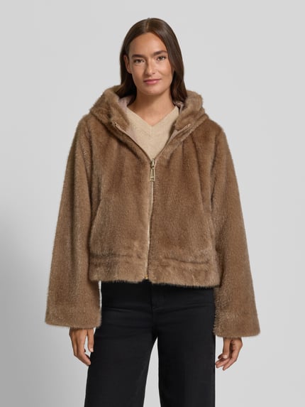 Frauenmodel trägt Jacke mit Kapuze und Kimonoärmeln von Liu Jo in Beige mit Reißverschluss, weiche Felloptik, Ganzkörperansicht von vorne. Gerader Schnitt, Maße S: Rückenlänge 54 cm, Schulterbreite 38 cm, Brustweite 56 cm, Ärmellänge 92 cm.