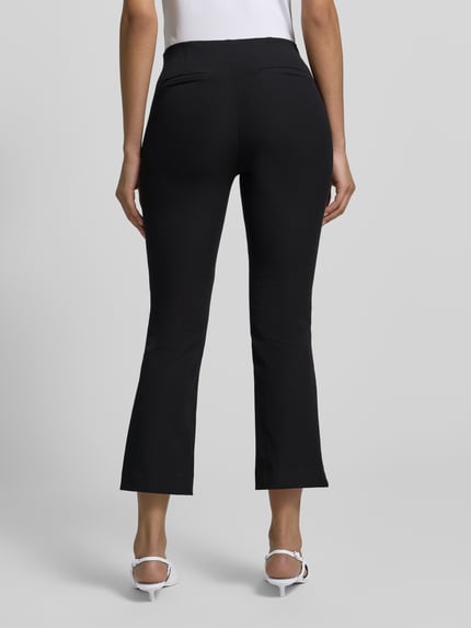 Vrouwenmodel draagt Flared Stoffhose met Nahtreißverschluss van Jake*s Collection, zwarte flared cut dames stoffen broek met steekzakken, achterzakken, bandwijdte maat 36 39 cm, binnenbeenlengte 66 cm, volledige lichaamsweergave achteraan.