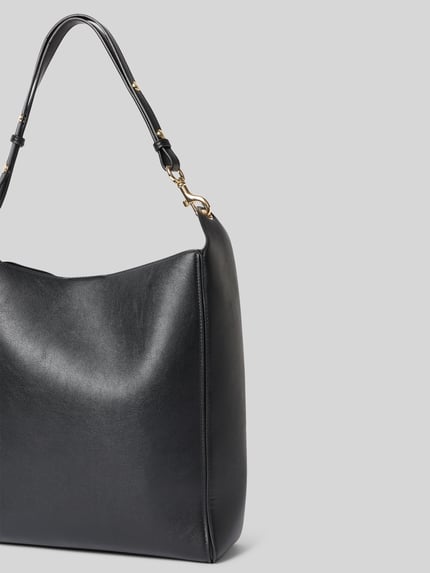 Produktfoto, schwarze Handtasche mit Magnetverschluss Modell 'DALMA' von MANGO, glatte Oberfläche, goldener Karabinerverschluss, neutraler Hintergrund