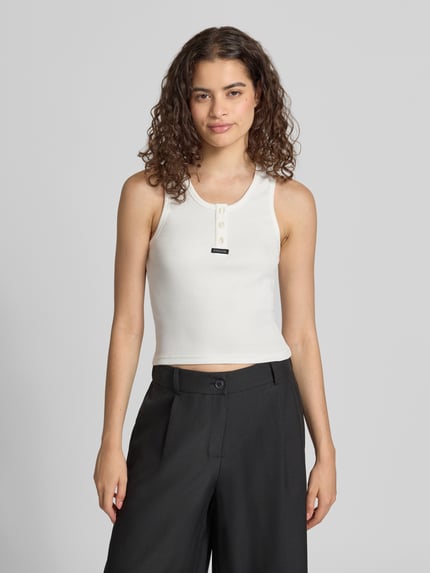 Vrouwenmodel draagt Slim Fit Top aus Baumwolle-Mix mit Logo-Print van 7608951 in effen wit met knoopsluiting, logoprint op voorkant, katoenmix, slim fit, ruglengte bij maat S 44 cm, Ganzkörperansicht van voren.