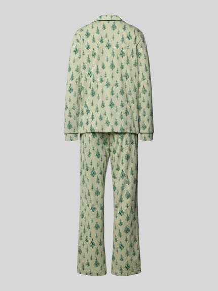 Frauenmodel trägt Pyjama aus reiner Baumwolle Modell 'X-Mas' von LASCANA mit grünem Tannenbaum-Muster, lockerer Schnitt, Ganzkörperansicht Rückansicht.