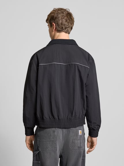 Männermodel trägt Regular Fit Blouson mit Kontraststreifen Modell 'HEIGHTS PIPPING JACKET' von Levi's®, unifarben, gerippte Bündchen, ganzkörperansicht rückansicht.