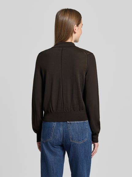 Frauenmodel trägt Pullover aus Schurwolle mit Polokragen Modell 'MYNERVA' von DRYKORN in Uni-Optik, Feinstrick, lange Ärmel, elastische Abschlüsse, Ganzkörperansicht Rückansicht.