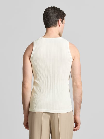 Männermodel trägt Tanktop mit Rundhalsausschnitt von Wood Wood aus Baumwoll-Mix in Beige, Ripp-Optik, Slim Fit, Ganzkörperansicht Rückansicht.