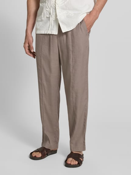 Männermodel trägt Straight Fit Schmale Hose aus Leinen-Lyocell-Mix Modell 'CINO' von HUGO, Optik: Unifarben, Nahaufnahme Unterkörper.