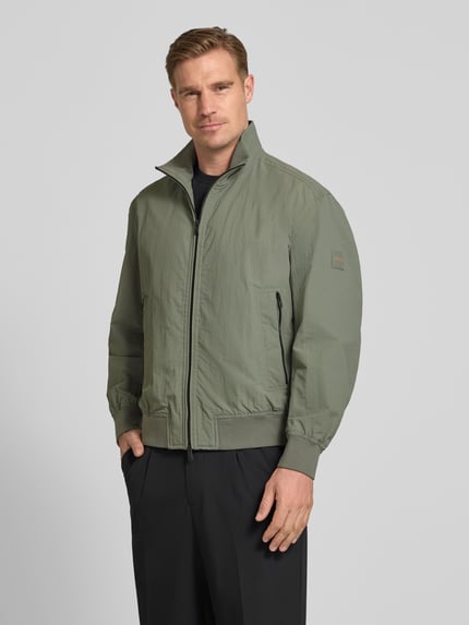 Männermodel trägt Relaxed Fit Blouson aus wasserabweisendem Material Modell 'OPENS' von BOSS Orange, Optik: Unifarben, Stehkragen, Zweiwege-Reißverschluss, Label-Patch, Langarm, Ärmelabschluss: gerippt, Rumpfabschluss: gerippt, seitliche Eingrifftaschen, Ganzkörperansicht von vorne.