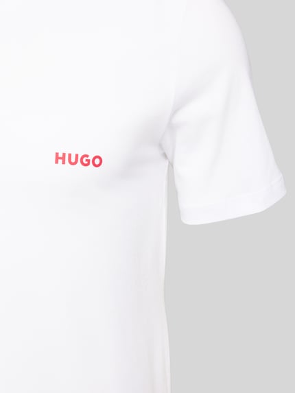 Männermodel trägt T-Shirt mit Label-Print im 3er-Pack von HUGO in Unifarbenes-Design aus Reine Baumwolle, Nahaufnahme Oberkörper.