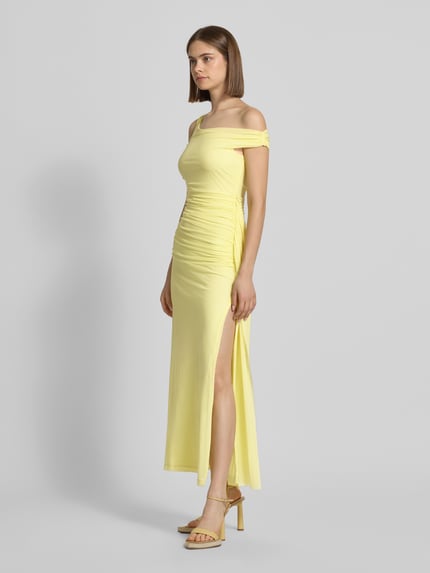 Frauenmodel trägt Abendkleid mit asymmetrischem Ausschnitt Modell 'LAYANA' von Bardot in Hellgelb, Material-Mix mit Stretch-Anteil, Körpernaher-Schnitt, Maxikleid, Raffung seitlich, Schlitze, glatte Textur, Ganzkörperansicht von vorne.