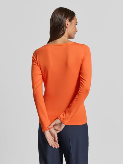 Frauenmodel trägt Slim Fit Langarmshirt aus Baumwoll-Mix von Marc Cain in Orange, glatte Textur, U-Boot-Ausschnitt, Rückenlänge 58 cm, Ganzkörperansicht Rückansicht.