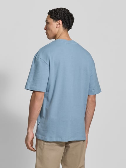 Männermodel trägt hellblaues T-Shirt mit Rundhalsausschnitt Modell 'KAISER' von Blend aus Baumwolle, Relaxed Fit, Ganzkörperansicht Rückansicht.