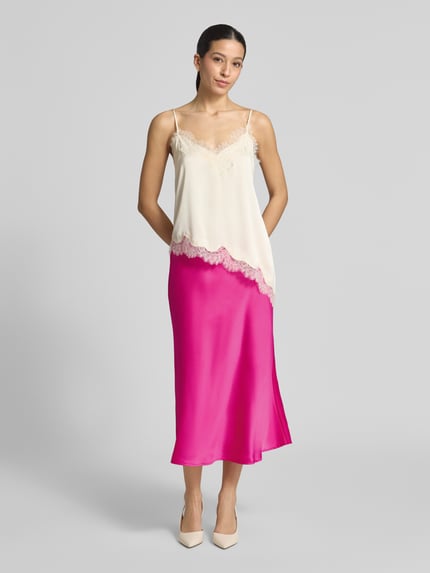 Frauenmodel trägt Midirock mit elastischem Bund Modell 'YASPELLA' von YAS aus Elastischer-Material-Mix, A-Linie, pink, Ganzkörperansicht von vorne.