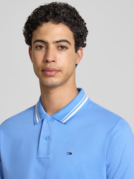 Männermodel trägt Regular Fit Poloshirt aus reiner katoen van Tommy Jeans, look: effen, korte mouw, polokraag, gestikt logo, 2-knoopsluiting, jersey, Nahaufnahme Oberkörper.