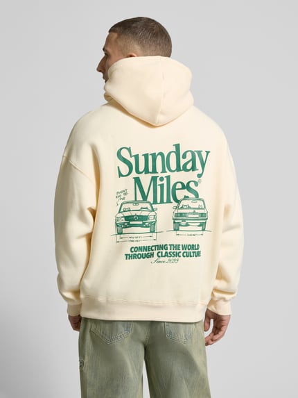 Männermodel trägt Hoodie mit Logo-Prints Modell 'Sunday Miles' von ANOTHER COTTON LAB in Creme und Grün, Baumwoll-Mix, Rückenansicht