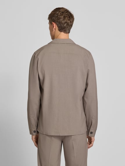 Männermodel trägt Relaxed Fit Hemdjacke mit Brusttaschen von Lindbergh aus Material-Mix mit Viskose-Anteil in Beige, Ganzkörperansicht Rückansicht. Rückenlänge bei Größe M: 73 cm, Kentkragen, Knopfleiste.