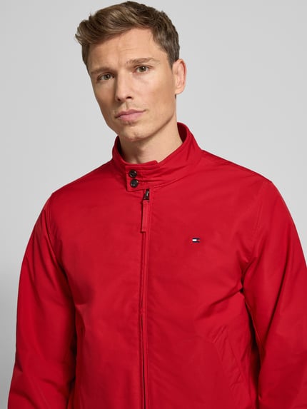 Mannelijk model draagt Relaxed Fit Blouson met Logo-Stitching van Tommy Hilfiger in effen rood, met opstaande kraag en geribde boorden, Nahaufnahme Oberkörper.