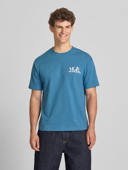 Männermodel trägt Relaxed Fit T-Shirt aus reiner Baumwolle von Marc O'Polo Denim, Optik: Unifarben, Label-Print, Ganzkörperansicht von vorne.