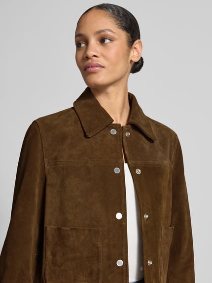Modelka nosi Regular Fit Jacke in Leder-Optik od Jake*s Casual, brązowy materiał skóropodobny, wykładany kołnierz, nakładane kieszenie, listwa guzikowa, stylizacje casualowe, ujęcie: zbliżenie górnej części ciała z przodu.