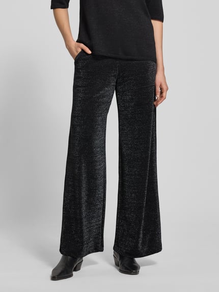 Vrouwenmodel draagt Stoffhose mit elastischem Bund van Milano Italy, zwart met glitter-effect, losse pasvorm, zicht op Franse zakken, detailopname onderlichaam.