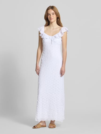 Vrouwenmodel draagt midi-jurk met kant en strikdetail van Gina Tricot, materiaalmix met stretch, nauwsluitend model, volants, hartvormige hals, ruglengte maat S 117 cm, borstwijdte maat S 32 cm, volledig wit, gestructureerd oppervlak, geheel lichaamsaanzicht van voren.