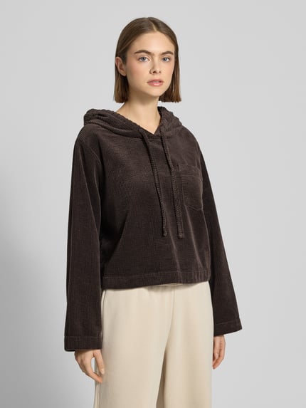 Frauenmodel trägt Oversized Hoodie aus reiner Baumwolle von Marc O'Polo Denim, Optik: Unifarben, Passform: Oversized, Struktur, Cord, Label-Stitching-Applikation, Kapuze mit Tunnelzug, Langarm, überschnittene Schultern, Materialverarbeitung: reine Baumwolle, Ganzkörperansicht von vorne.