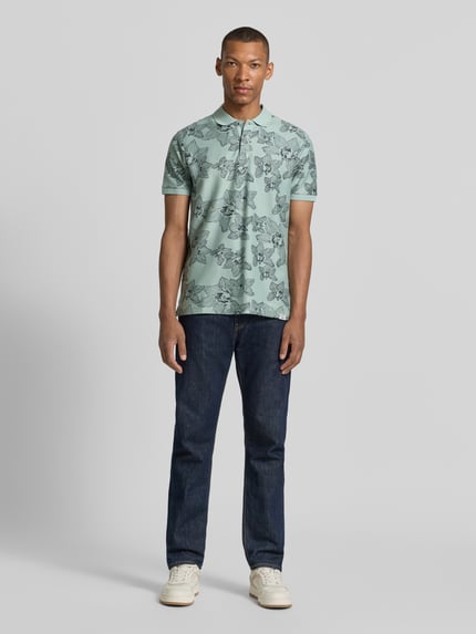 Männermodel trägt Slim Fit Poloshirt mit floralem Allover-Print von Lerros in Mintgrün aus Reiner Baumwolle, Polokragen, Kurzärmelig, Ganzkörperansicht von vorne.