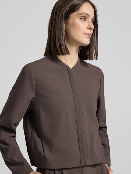 Frauenmodel trägt Blouson mit Viskose-Anteil von COMMA in Braun, elastischer Material-Mix, lockere Passform, Nahaufnahme Oberkörper.