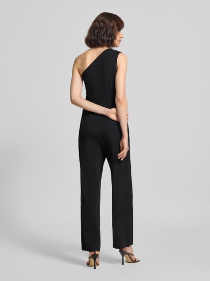 Vrouwenmodel draagt Jumpsuit met Stretch-Anteil van Oui in zwart, getailleerde pasvorm, one-shoulder design, tailleband, mouwloos, elastische materiaalmix, totale lengte 142 cm, binnenbeenlengte 78 cm, ruglengte 40 cm, borstwijdte 38 cm, geheel zicht van achteren.